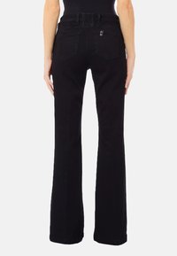 Črne razširjene jeans hlače iz jeansa, z visokim elastičnim pasom in dvema zadnjima žepoma s subtilnimi detajli šivov.