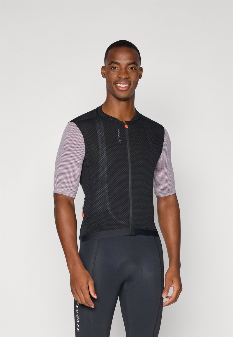 Maillot de cyclisme en mesh noir avec des manches courtes à motifs, fermeture éclair à l'avant et accents orange. Porté par-dessus un short de cyclisme noir.