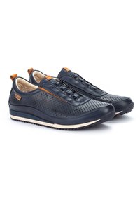Scarpe sportive in pelle blu navy con una parte superiore testurizzata, perforazioni per la traspirabilità, lacci elasticizzati e suola bianca con battistrada nero.