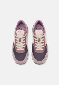 Paire de baskets Pepe Jeans violettes, noires et crème avec des lacets, vues de dessus sur un fond blanc.