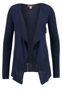 Námořnický modrý cardigan vyrobený z žebrovaného úpletu, s otevřeným předním dílem, dlouhými rukávy a uvolněným, mírně asymetrickým lemem.