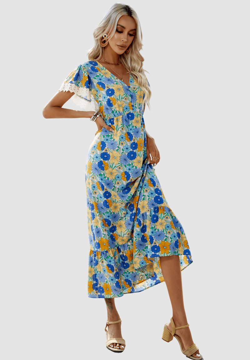 Vestido de verano floral en azul, amarillo y verde. Presenta mangas cortas con volantes, un escote en V y un dobladillo en capas. Está hecho de una tela ligera.
