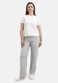 White short-sleeve t-shirt paired with gray vertical striped wide-leg pants. The pants feature a textured weave and elastic waistband. White sneakers.