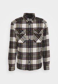 Camicia in flanella con bottoni, a fantasia a quadri nera, bianca e gialla, con due tasche sul petto e maniche lunghe. Tessuto texturizzato.