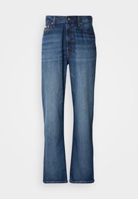 Jeans in denim blu con vita alta, gambe a zampa d'elefante, design a cinque tasche e cuciture tono su tono. Presentano un bottone alla vita e tasche ribattute.