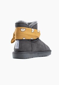 Stivale alla caviglia in suede grigio con un fazzoletto giallo a fantasia avvolto attorno alla parte superiore. Fodera interna grigia morbida e suola in gomma.
