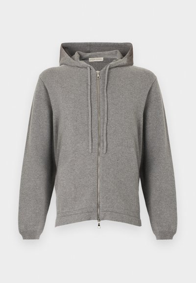 Ανοιχτό γκρι hoodie με φερμουάρ, κορδόνια και μπροστινές τσέπες, κατασκευασμένο από μαλακό πλεκτό ύφασμα, απλωμένο επίπεδα σε λευκό φόντο.