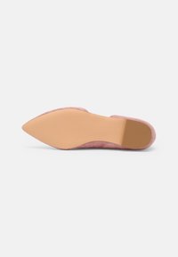 Chaussure plate en daim rose à bout pointu, vue depuis la semelle, mettant en valeur la semelle extérieure beige lisse et le petit talon.