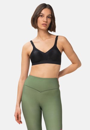 Reggiseno nero con spalline regolabili, design a scollo a V, texture liscia e leggera imbottitura, abbinato a leggings verdi a vita alta.