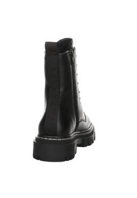 Bota de cuero negra hasta el tobillo con suela gruesa, cierre de cremallera en la parte trasera y detalles texturizados a lo largo del costado. Diseño resistente y robusto.