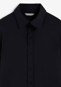 Navy button-up shirt met een spread collar, met een simpele textuur en zeven knopen aan de voorkant. Het label leest "SCALPERS" binnenin de kraag.
