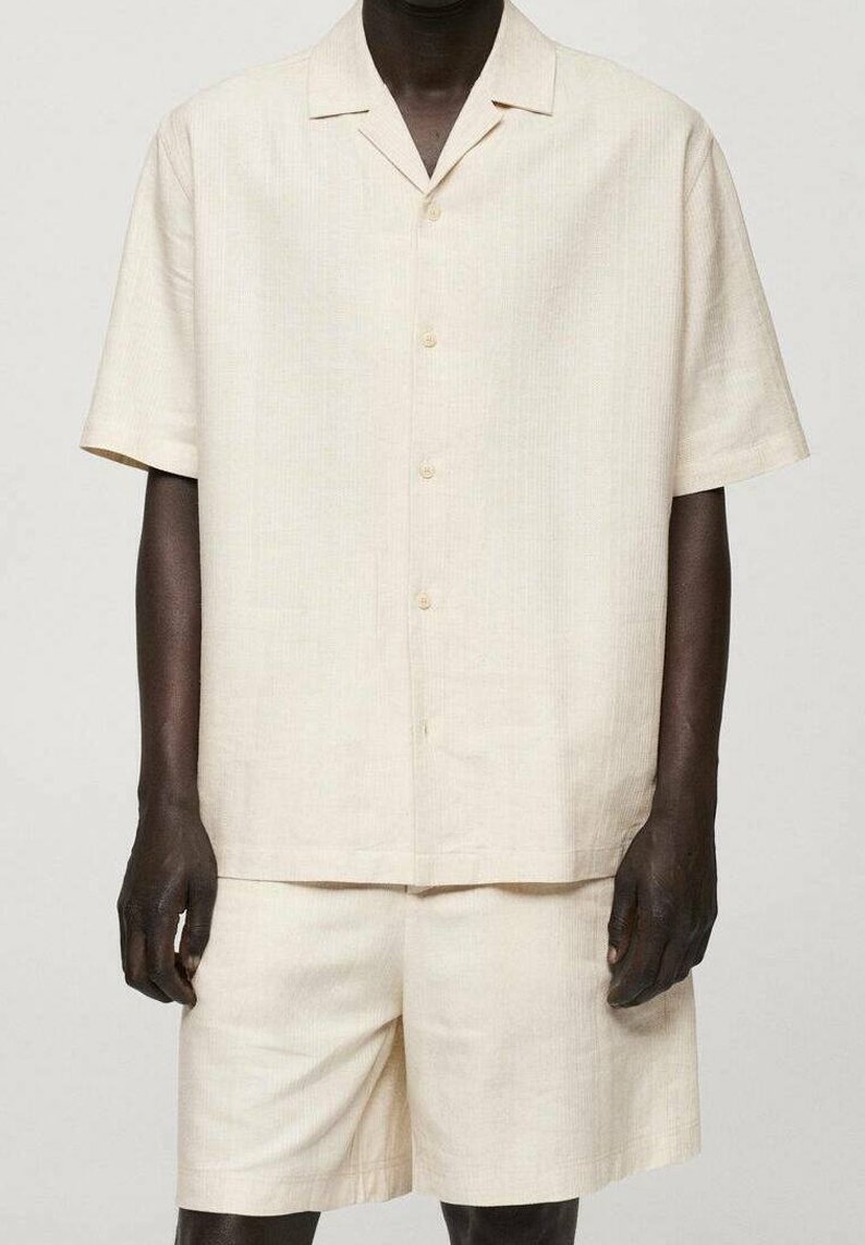 Beiges Hemd mit kurzen Ärmeln und Knopfleiste sowie passenden Shorts aus strukturiertem Stoff, mit Hemdkragen und lockerem Schnitt.