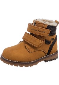 Stivaletto in suede marrone con due cinturini regolabili in Velcro, foderato in pelliccia sintetica, suola in gomma e dettagli in pelle nera a contrasto.
