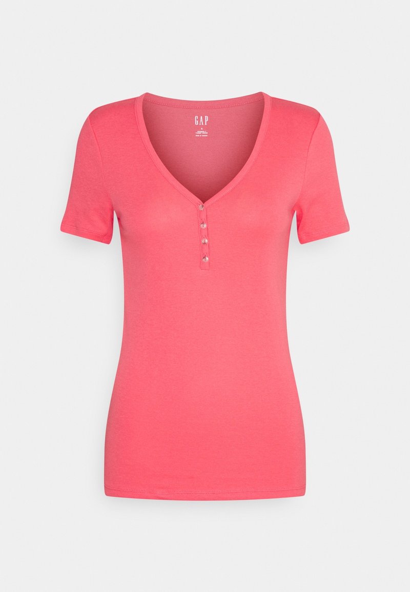 Damska koszulka w kolorze koralowego różu z krótkim rękawem, dekoltem w serek i czterema małymi guzikami na środku przodu.