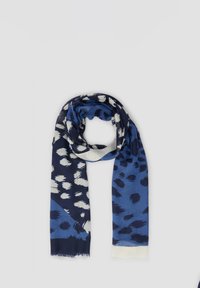 Écharpe bleu marine et bleu clair en tissu doux, arborant un motif de coups de pinceau et de points, avec des bords frangés pour une texture ajoutée.