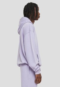 Lavendel Hoodie mit lockerer Passform, langen Ärmeln und gerippten Bündchen. Weiche Textur und geräumige Kängurutasche.
