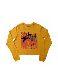 Long-sleeve mustard yellow crop top made of cotton, featuring a black and pink Slipknot graphic design and front print detail.