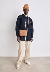 Calvin Klein RE-LOCK CAMERA BAG FLAP - Umhängetasche - lion