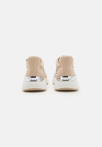 Lyse rosa sneakers med en glatt tekstur, med en hvit såle og skinnende sølvdetaljer på hælen. Chunky design, snøring.