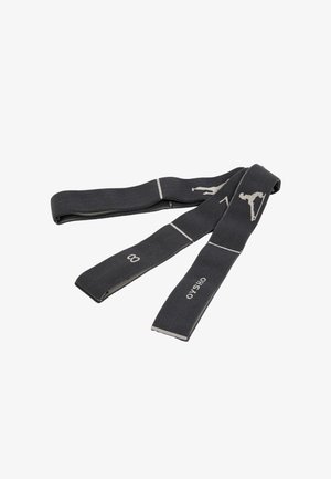 Bande de résistance en tissu noir avec des icônes blanches de positions d'exercice et le logo "OYSHO" posée à plat sur un fond blanc.