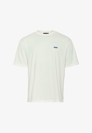 Fehér pamut póló kerek nyakkal, rövid ujjakkal, laza szabással és egy kis kék logopatch-el a bal mellkas térségében.