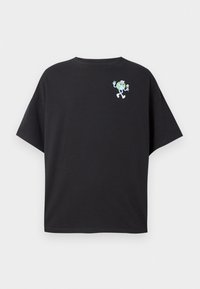 Svart T-skjorte med kort arm laget av bomull, med et grønt karaktergrafikk på øvre venstre side, smilende og holder blomster.