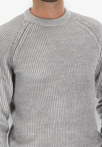 Maglione grigio a coste con scollatura rotonda, tessuto testurizzato e maniche a raglan. Il motivo è composto da strisce sottili e spesse alternate.