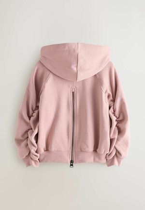 Růžová mikina s kapucí a zipovým zapínáním, s nařasenou texturou na rukávech a dolním lemu, vyrobená z měkkého materiálu, s rovnými liniemi.