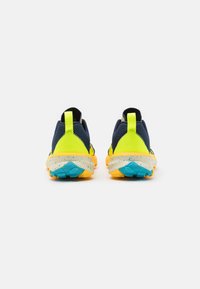 Chaussures de sport bleu et jaune néon avec une tige en mesh texturé, un col rembourré et une semelle extérieure jaune mouchetée. Accents réfléchissants sur le talon.