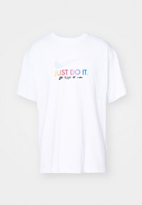 Balta medvilnės marškinėliai su trumpomis rankovėmis, kuriuose yra daugiaspalvis užrašas "TIESIOG DARYK TAI." ir Nike logotipas priekyje.