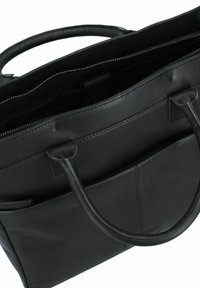 Schwarze Leder-Tote-Bag mit zwei oberen Griffen, Reißverschluss und Außentasche. Glatte Textur und minimalistisches Design.