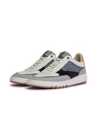 Sneaker bianche e grigie con un mix di materiali scamosciati e tessili, caratterizzate da un accento blu navy, una linguetta testurizzata e una suola in gomma a zigzag.