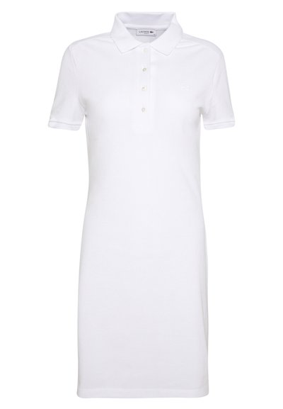 Robe polo blanche en coton, dotée d'un col, de manches courtes, d'une patte de boutonnage à cinq boutons et du logo Lacoste sur la poitrine.