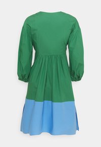 Robe colorée en blocs vert et bleu avec de longues manches bouffantes, taille froncée et encolure ronde, fabriquée en coton léger.