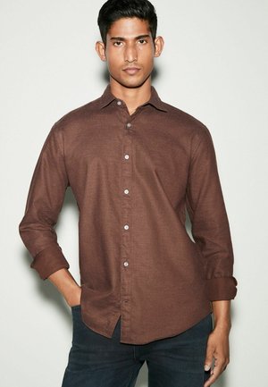 Camicia marrone a maniche lunghe con bottoni, realizzata in tessuto testurizzato, con colletto, chiusura frontale con bottoni e maniche arrotolate.