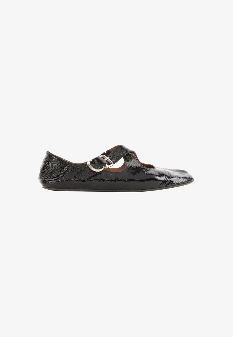 Chaussure plate en cuir verni noir avec bout pointu et bride à boucle argentée sur le cou-de-pied sur fond blanc.