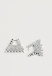 Ασημένια τριγωνικά σκουλαρίκια με στρογγυλές χάντρες κατά μήκος των ακμών και ένα λογότυπο στο κέντρο, κατασκευασμένα από μεταλλικό υλικό με λεία φινίρισμα.