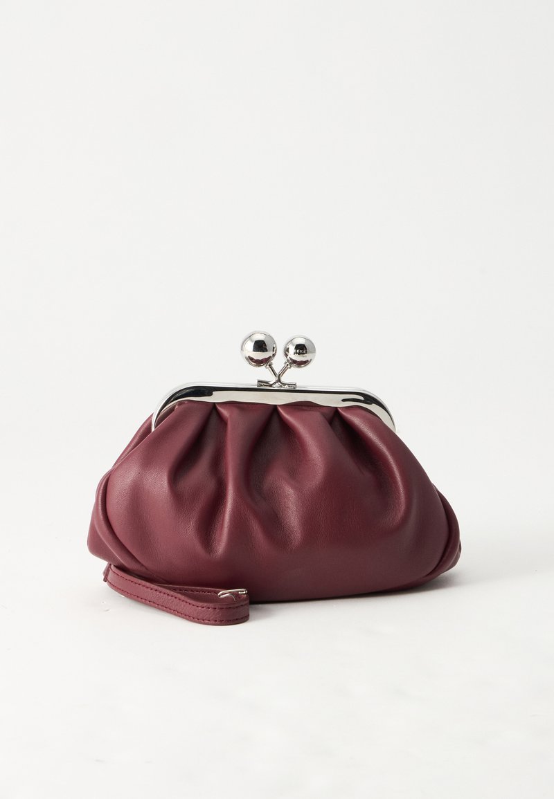 Petit sac pochette en cuir bordeaux avec fermoir métallique argenté et bracelet sur fond blanc.