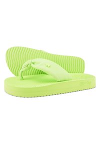 Green flip-flops with a textured outsole and smooth strap. The strap features a small emblem. Lightweight and flexible in design.