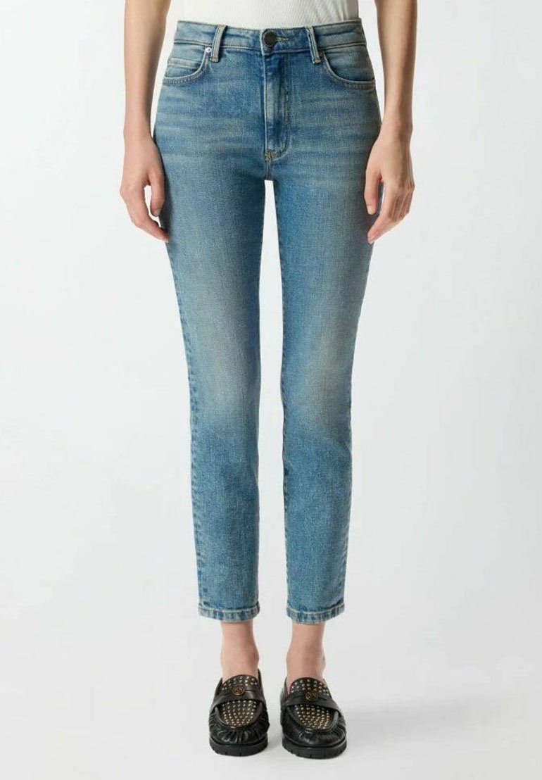 Jean en denim bleu clair avec une coupe ajustée, légère décoloration, design à cinq poches et fermeture à bouton à la taille. Longueur chevilles raccourcie.