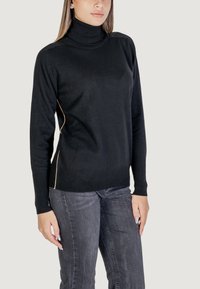 Pull noir à col roulé avec des poignets et un ourlet côtelés, arborant un discret design de couture latérale en couleur contrastante. Matière douce et ajustée.