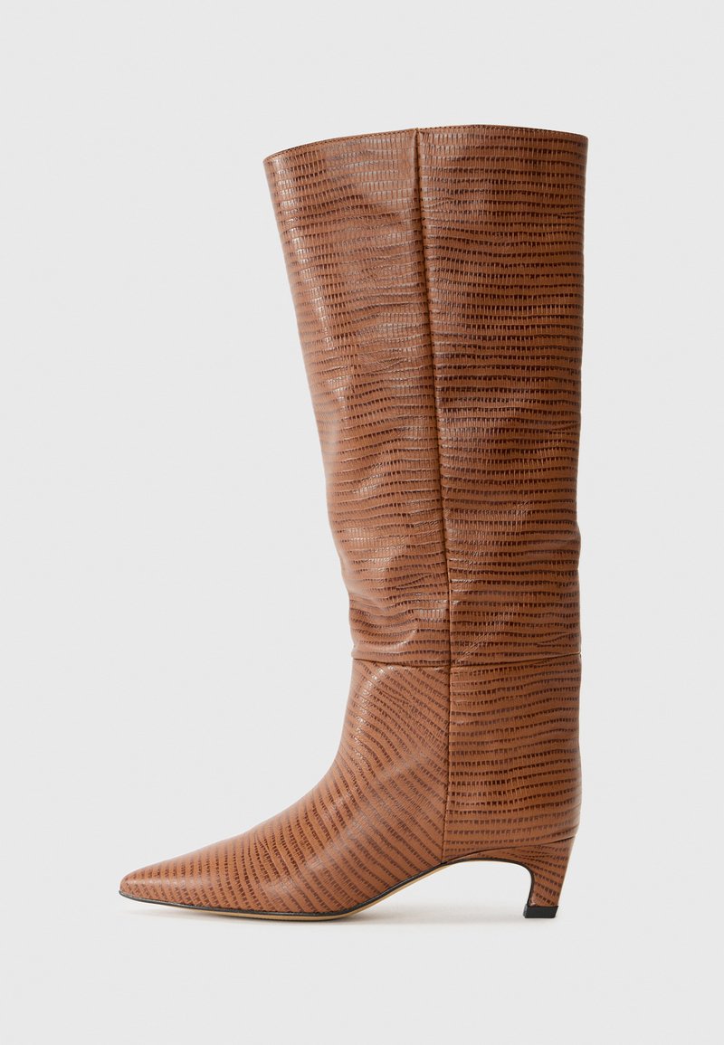 Botte haute en cuir brun texturé avec un bout pointu et un talon bas, présentant un motif rayé distinctif et une finition lisse.