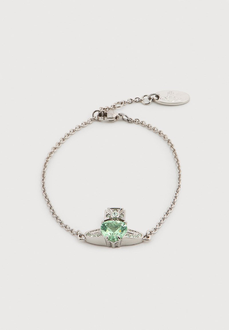 Ασημένιο βραχιόλι με αλυσίδα που διαθέτει μια καρδιά από πράσινη πέτρα πολύτιμη στο κέντρο, διακοσμημένο με μικρές διαυγείς πέτρες και μεταλλική ετικέτα.