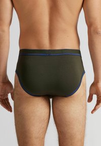 Ciemnozielone bawełniane slipy z niebieską elastyczną taśmą w pasie i szwami. Mają dopasowany krój i klasyczny styl slipów.