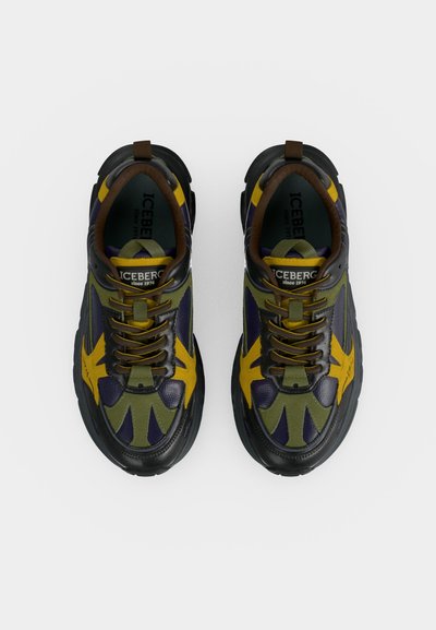 Paire de baskets noires, vertes et jaunes avec lacets et nom de la marque "ICEBERG" visible sur la languette, vues de dessus.