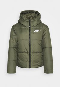 Chaqueta acolchada verde con capucha, que presenta un cierre frontal con cremallera, cordones elásticos y un pequeño logo blanco en el pecho.