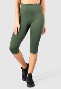 Leggings verdi a vita alta, realizzati in tessuto elastico. Caratterizzati da una superficie liscia e senza motivi o accessori visibili.