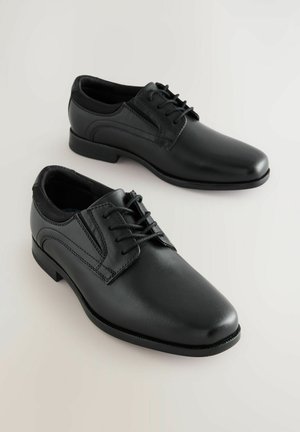 Pantofi de dress din piele neagră cu un finisaj lustruit, vârf rotunjit, sistem de închidere cu șireturi și detalii subtile de coasere pe laterale.