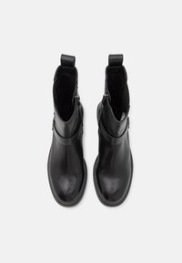 Black leather ankle boots with a smooth finish, featuring a side zipper and pull tab. The design has a sleek, minimalist silhouette.