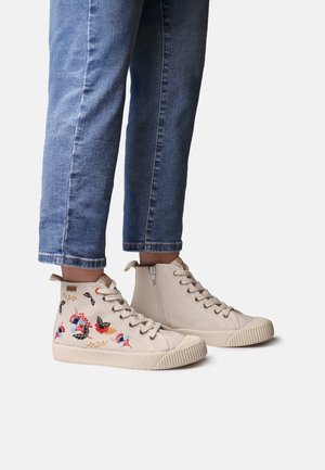 Visoki supergi iz bež platna z rožnim vezenjem, s teksturirano gumijasto podplatom in stranskim zadrgo za enostavno uporabo.